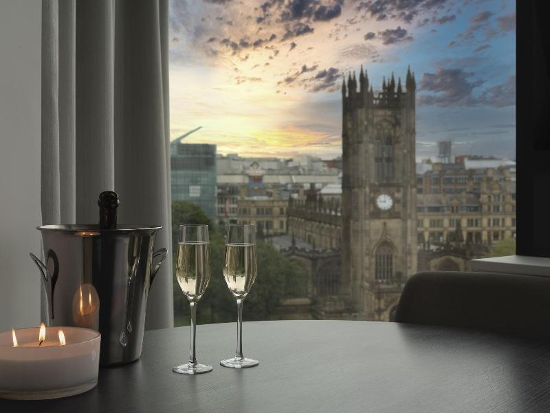 Citysuites Aparthotel Salford  Ngoại thất bức ảnh The photo shows a cozy indoor setting with a table that features two champagne glasses and a bottle of champagne in an ice bucket. There is also a lit candle on the table, enhancing the intimate atmosphere. In the background, large windows reveal a c