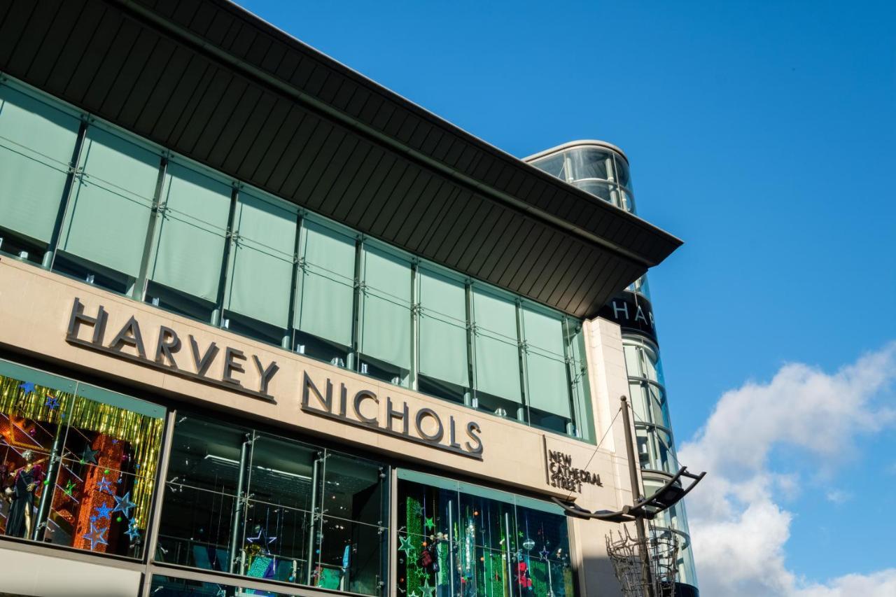 Citysuites Aparthotel Salford  Ngoại thất bức ảnh The photo shows the exterior of a retail building featuring the name "Harvey Nichols" prominently displayed. The architecture includes large glass windows, and the design appears modern and sleek. The sky above is bright blue, suggesting a sunny day,